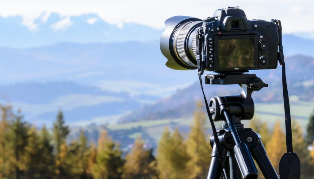 pexels-photo-212372 DSLR camera on tripod capturing a stunning mountain view on a clear day.